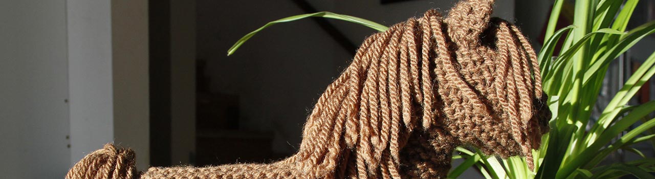cropped imaged: brown knit horse toy, green spider plant