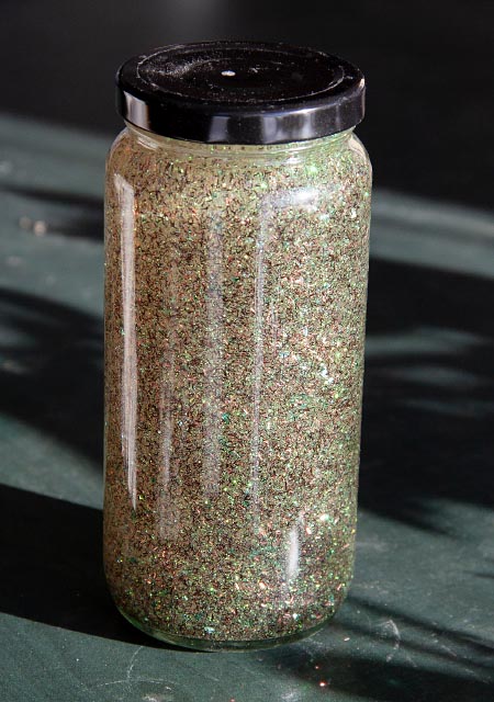 tall jar full of liquid and golden glitter